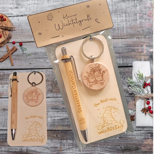 holz geschenkset in transparenter verpackung: bambus-kugelschreiber mit gravur namen, runder holz-schlüsselanhänger gravur wichtel auf auto alles zusammen auf holzkarte mit wichtel