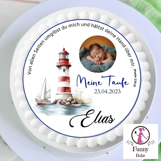 White cake with a circular topper showing a sleeping baby, lighthouse, sailboat, Elias's baptism text, date 23.04.2023, on a stand with Funny Bake logo.