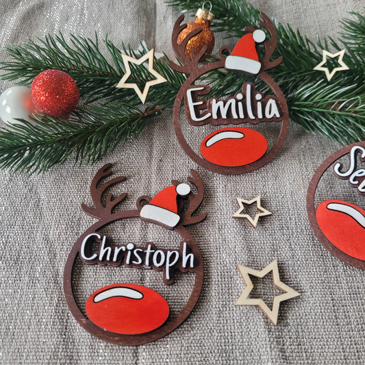 personalisierter weihnachtsanhänger aus holz in rentierform mit roter nase, weihnachtsmütze und wunschnamen – handgemacht als geschenkanhänger oder baumschmuck