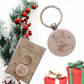 Runder Holz-Schlüsselanhänger mit Rentier-Motiv Gravur, ca. 4 cm, auf weihnachtlicher Geschenkverpackung.