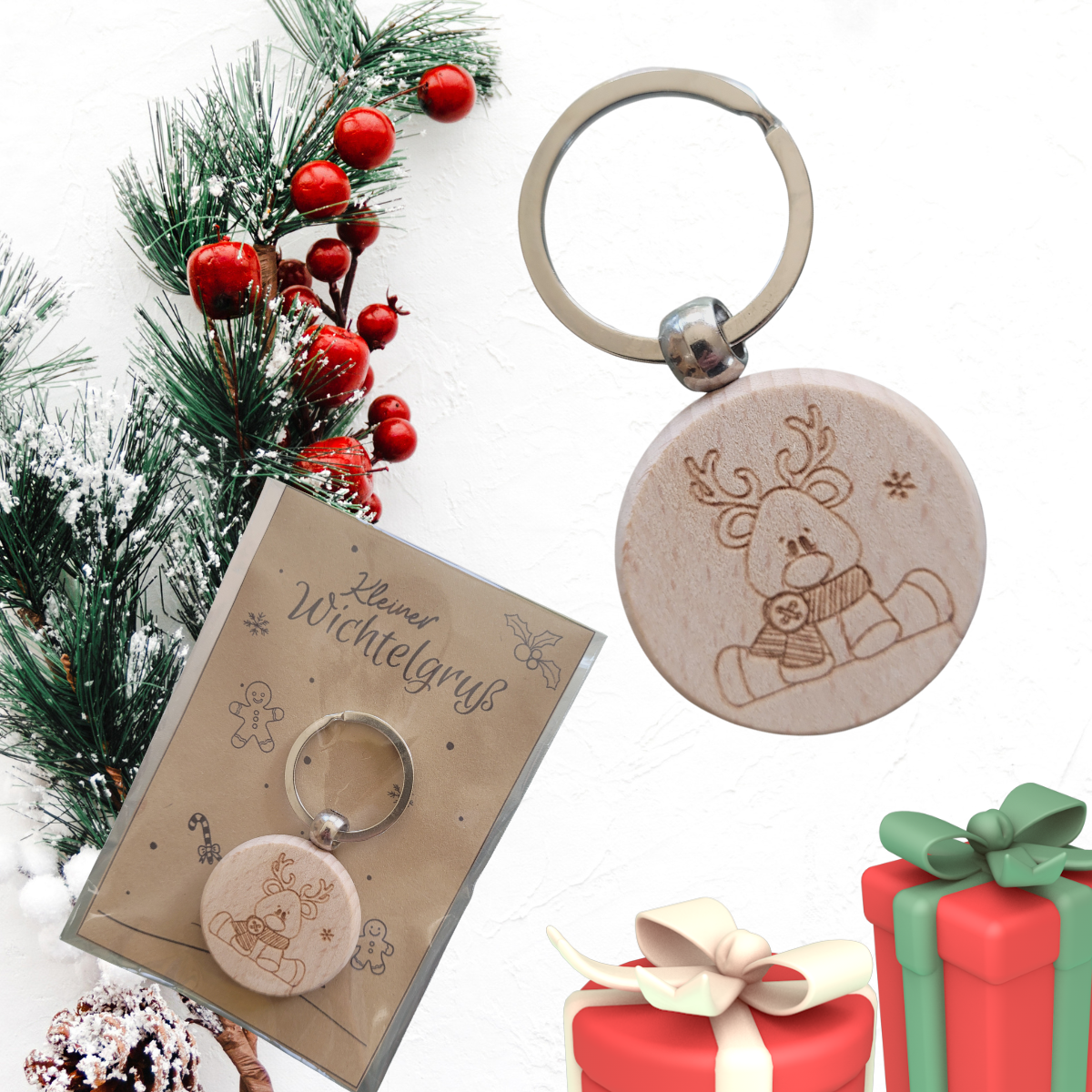 Runder Holz-Schlüsselanhänger mit Rentier-Motiv Gravur, ca. 4 cm, auf weihnachtlicher Geschenkverpackung.