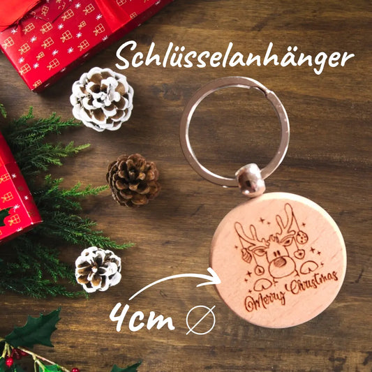 Runder Holz-Schlüsselanhänger mit Rentier-Motiv und Merry Christmas Gravur, ca. 4 cm, auf weihnachtlicher Geschenkverpackung.