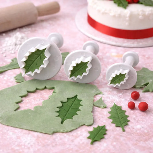 „Anwendung der Stechpalmenblatt Fondant Ausstecher – ausgerolltes grünes Fondant mit ausgestochenen Blättern und Beeren“