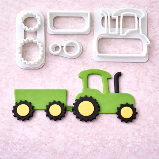 „Fondant Ausstecher Set Traktor mit Anhänger – Draufsicht auf alle Ausstecherteile und fertig ausgestochenen Traktor auf hellem Hintergrund“
