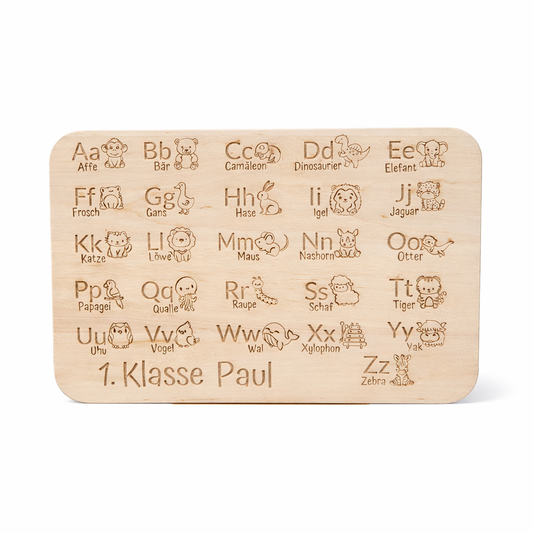 Personalisiertes Frühstücksbrettchen „Lesen lernen“ mit Alphabet-Motiv und Name „1. Klasse Paul“, freigestelltes Hauptbild mit leichtem Schatten