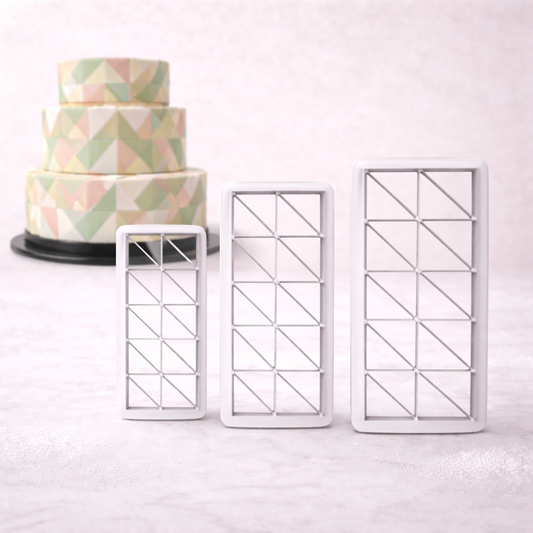Geometrischer Dreieck-Ausstecher in drei Größen beim Ausstechen von Fondant, mit Maßangaben für klein, mittel und groß