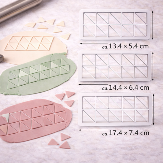 Geometrischer Dreieck-Ausstecher als Set in drei Größen vor einer modern dekorierten Torte mit Dreieckmuster