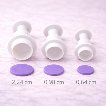 Drei Kreisausstecher mit Auswerfer in unterschiedlichen Größen übersichtlich nebeneinander auf heller Arbeitsfläche