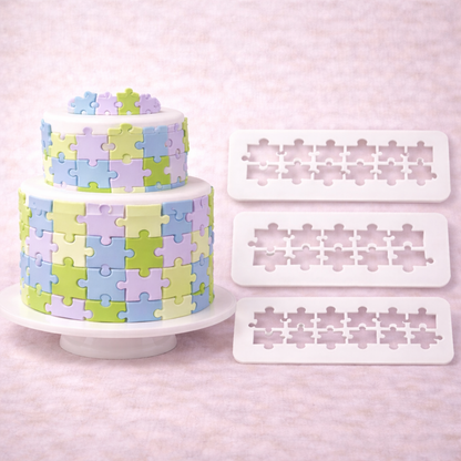 Multicutter Puzzle Ausstecher für Fondant in drei Größen neben einer zweistöckigen Torte mit Puzzle-Muster in Pastellfarben