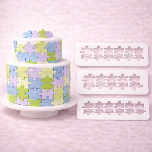 Multicutter Puzzle Ausstecher für Fondant in drei Größen neben einer zweistöckigen Torte mit Puzzle-Muster in Pastellfarben
