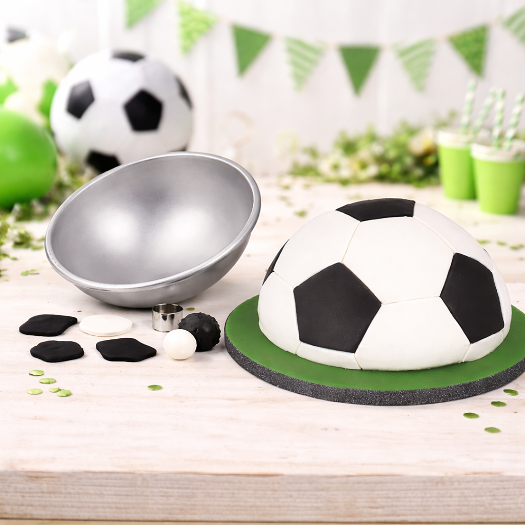 PME Halbkugel Backform 16 cm neben halber Fußballtorte auf dekoriertem Geburtstagstisch