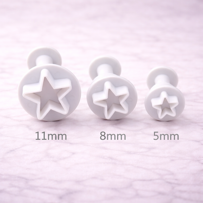 Drei Stern-Ausstecher mit Plunger-Funktion in unterschiedlichen Größen übersichtlich nebeneinander angeordnet