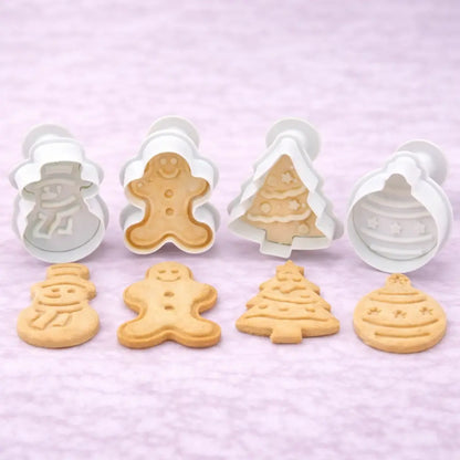 Vier Weihnachts-Ausstecher mit Stempel für Weihnachtsbäckerei, mit Motiven für Weihnachtskekse wie Schneemann, Lebkuchenmann, Tannenbaum und Christbaumschmuck