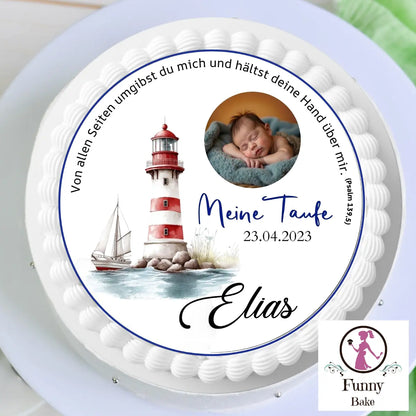 White cake with a circular topper showing a sleeping baby, lighthouse, sailboat, Elias's baptism text, date 23.04.2023, on a stand with Funny Bake logo.
