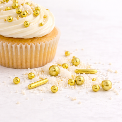 Minimalistischer Vanillemuffin mit weißem Frosting und gold-weißen Zuckerstreuseln auf hellem Hintergrund